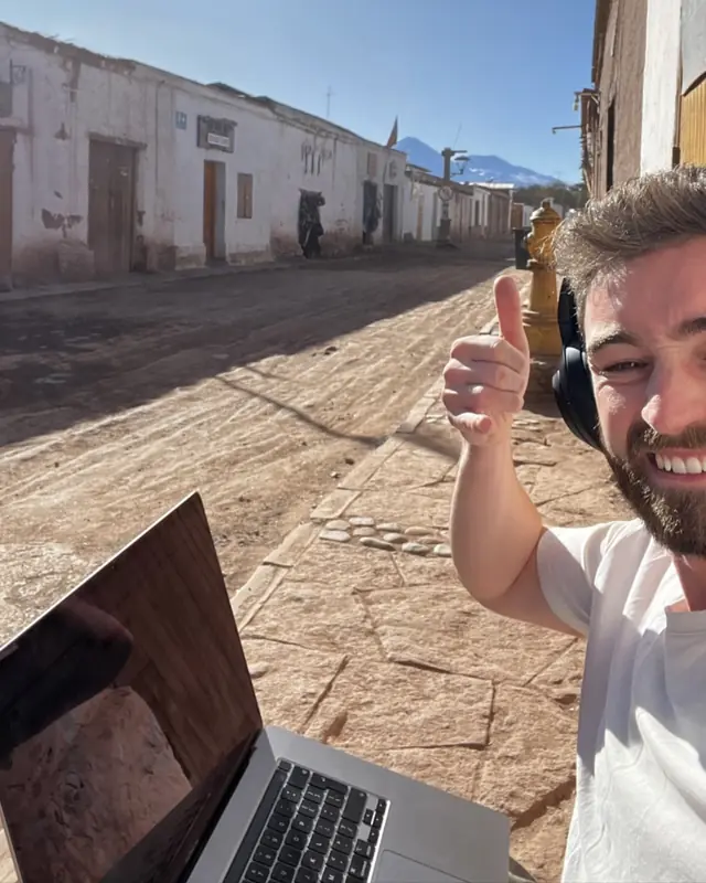 Patrick con laptop y auriculares trabajando en remoto en el desierto de Atacama, Chile