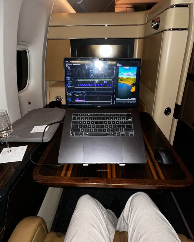 Patrick editando video en su laptop trabajando a 10.000 metros de altura en primera clase