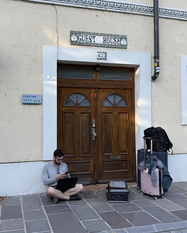 Patrick trabajando con su laptop frente a una guest house en Ljubljana, Eslovenia